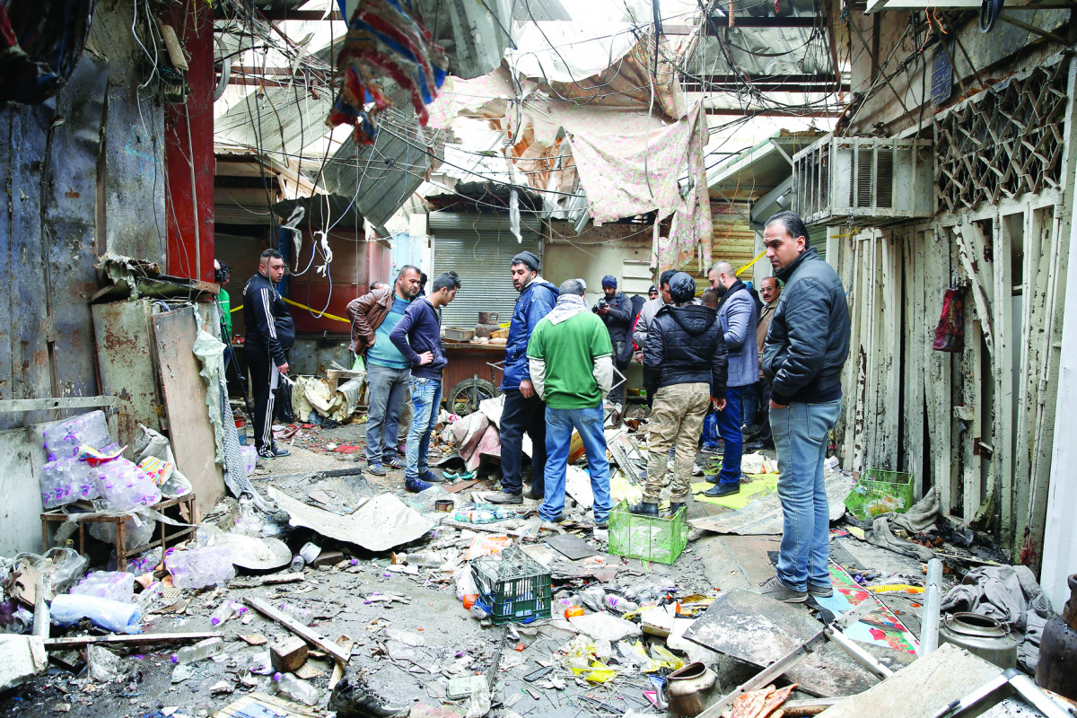 People inspect the scene of the suicide attacks at a bazaar in Baghdad,  yesterday.