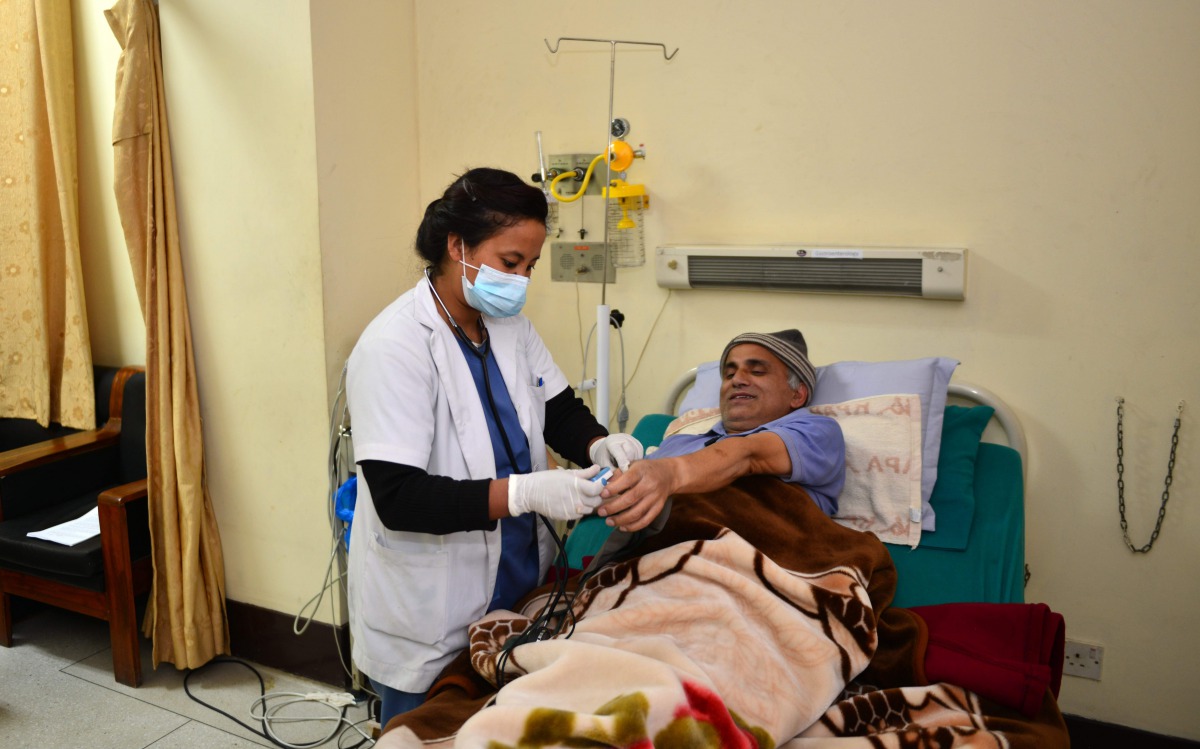 In this photograph taken on December 7, 2016, Nepalese orthopaedic surgeon Govinda KC has a sample taken by a medical attendant as he lies in a hospital bed in Kathmandu. Govinda KC spent 22 days lying on a gurney in a hospital in Nepal's capital Kathmand
