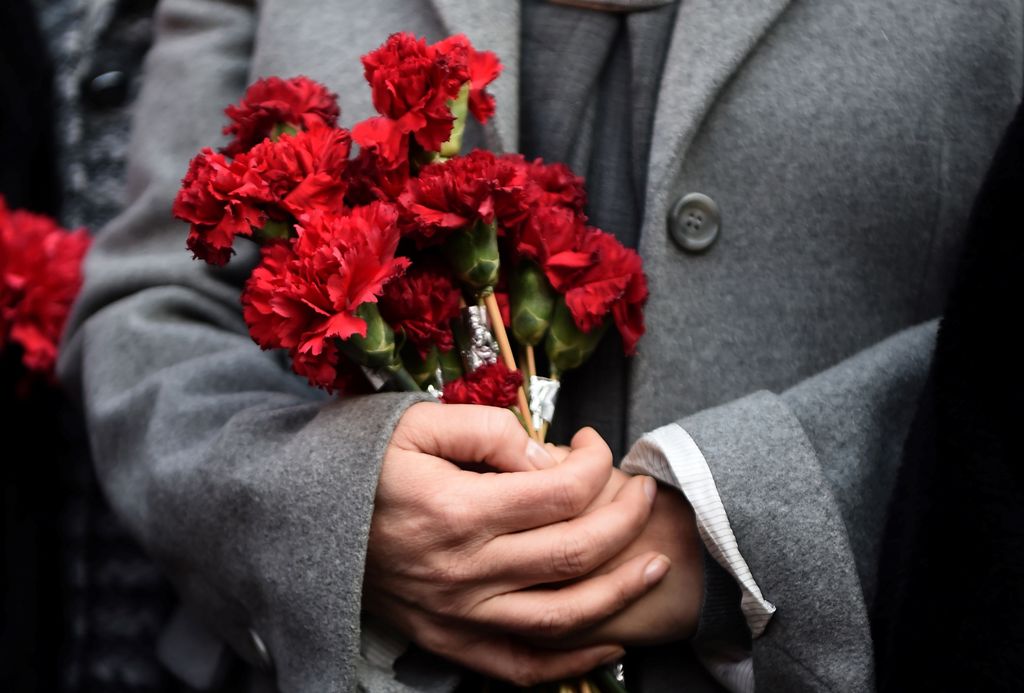 A woman holds flowers in front of the Reina night club, on January 2, 2017 in Istanbul, one day after a gunman killed 39 people, including many foreigners, in a rampage at an upmarket nightclub in Istanbul where revellers were celebrating the New Year. / 