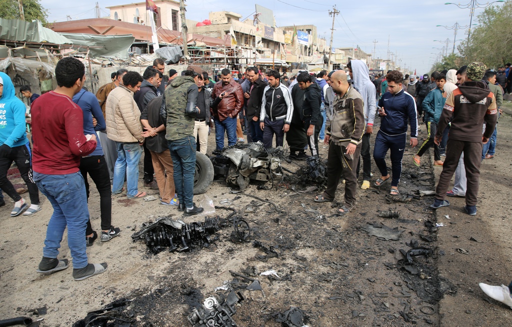 BAGDAD, IRAQ - JANUARY 2: People gather around remains of the wrecked vehicle following a blast, caused by a bomb-laden vehicle, at 55th Square in Sadr Region of Baghdad, Iraq on January 2, 2017. Scores of casualties reported. (Murtadha Sudani - Anadolu A