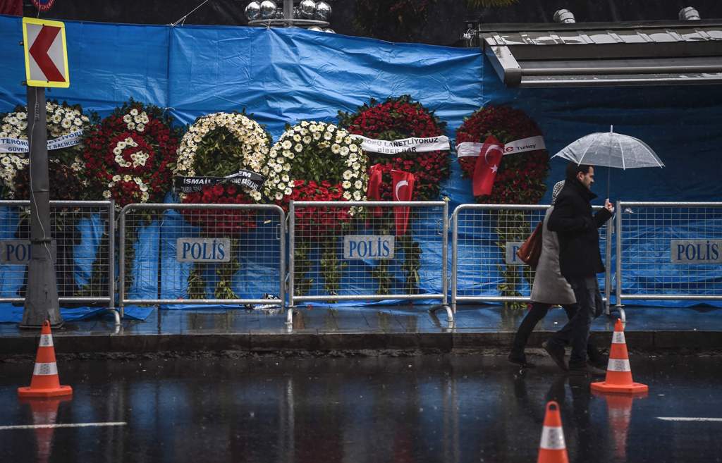 A couple walk past the Reina nightclub on January 5, 2017 in Istanbul, days after a gunman killed 39 people on New Year's night.  AFP / OZAN KOSE
