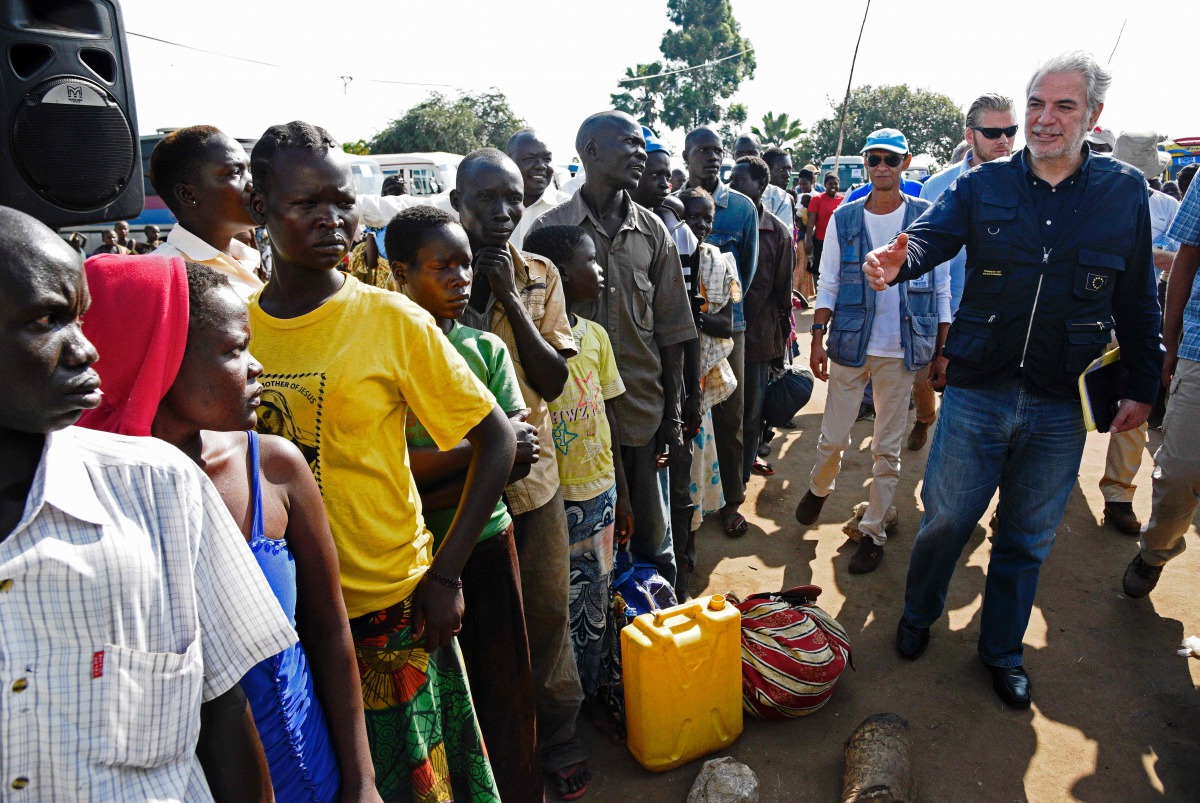 EU Commissioner for Humanitarian and Crisis Management Christos Stylianides speaks with newly arrived refugees from South Sudan to Uganda (AFP / ISAAC KASAMANI) 