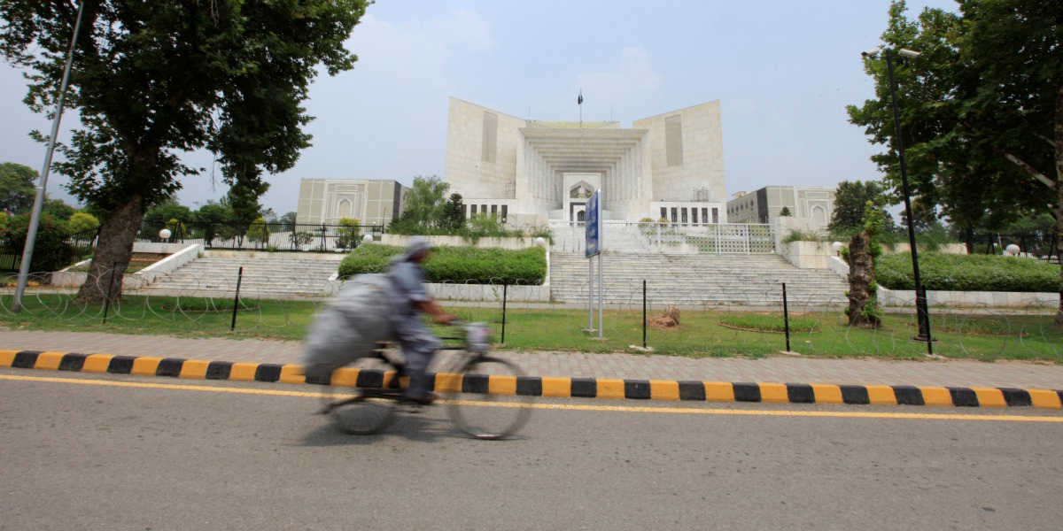 A man rides a bicycle past the Supreme Court building in Islamabad, Pakistan (REUTERS)
