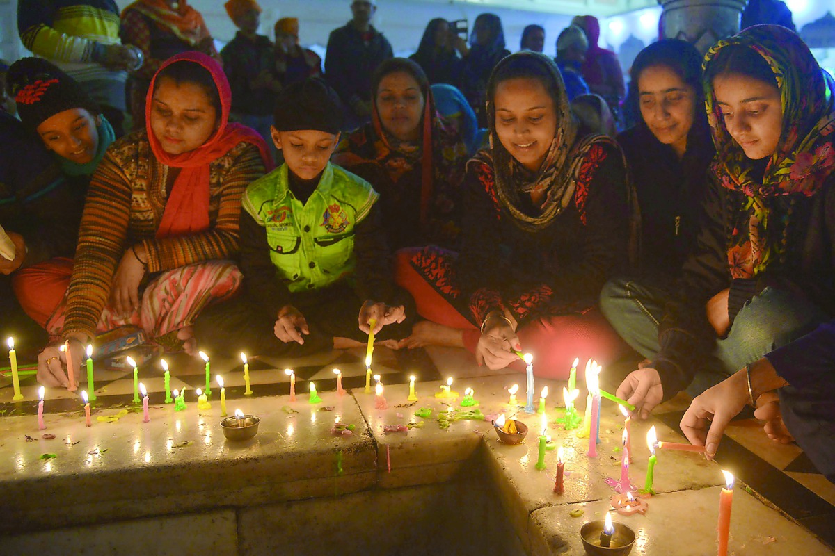 Sikh devotees light candles on occasion of the 350th birth anniversary of the 10th Sikh Guru Gobind Singh at the Sikh Shrine Golden Temple in Amritsar, yesterday.