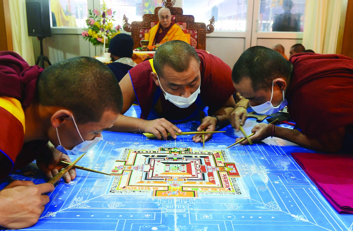 Tibetan Spiritual Leader The Dalai Lama looks on as Buddhist monks work on a traditional painting during a special religious prayer during the Kalachakra event at Bodhgaya, yesterday.