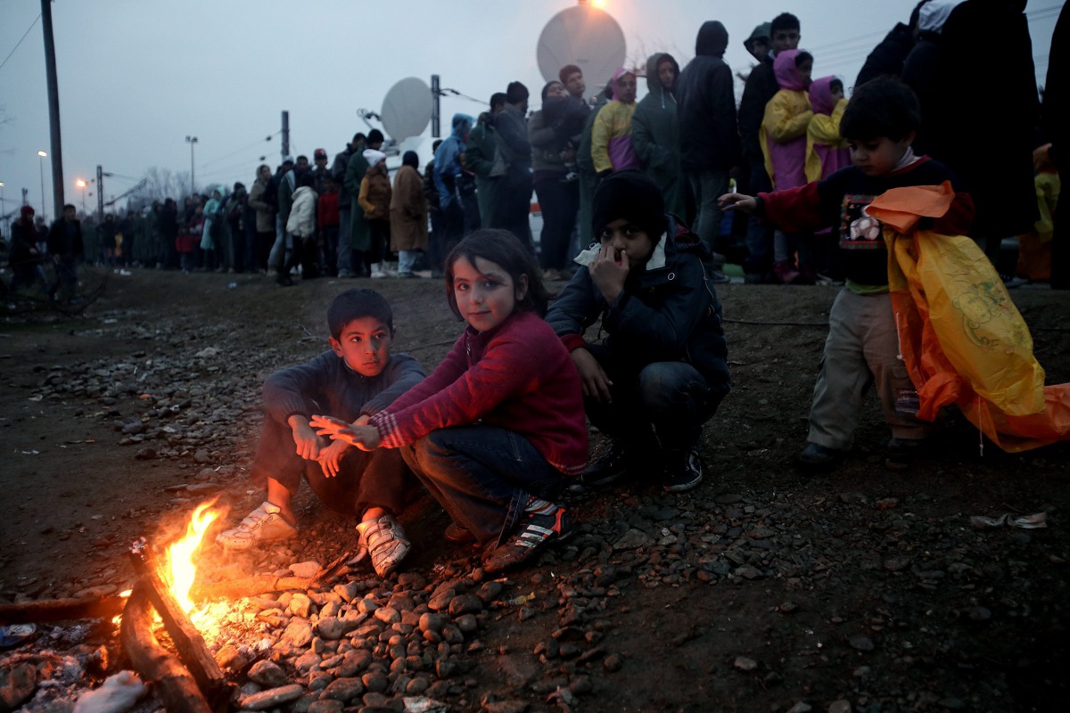 Refugees queue in a line to receive food from volunteers at the refugee camp in Idomeni, Greece, as they wait to be allowed to cross the border with FYROM, 29 February, 2016 (EPA / SIMELA PANTZARTZI)
