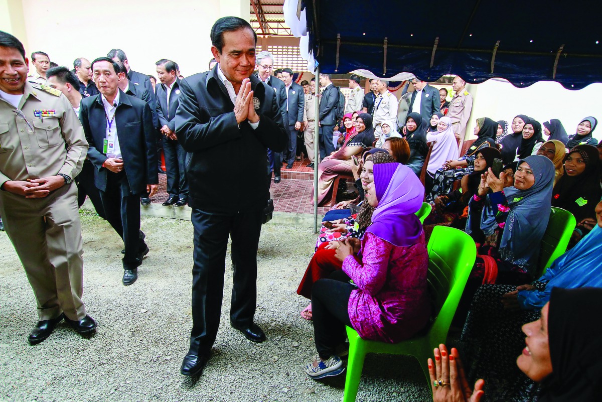 Thai Prime Minister Prayuth Chan-ocha gestures in traditional greeting during a visit at Ra-ngae district, yesterday.