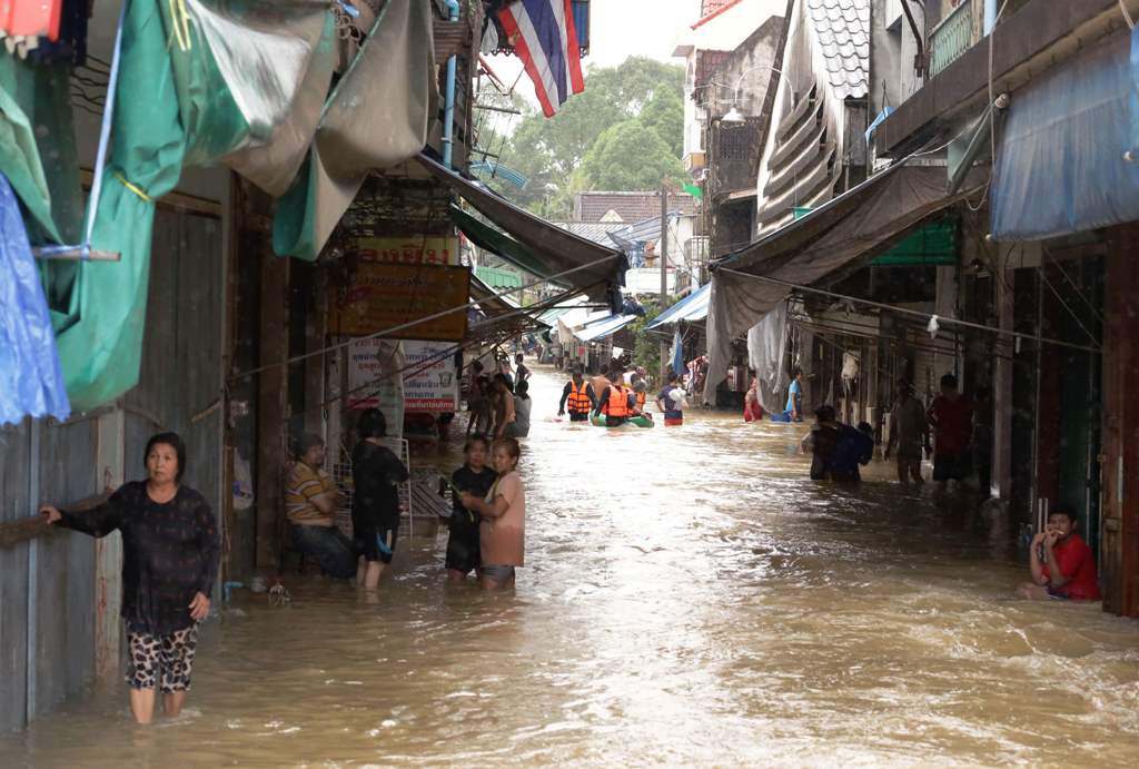 Residents stand in floodwaters in the southern Thai village of Chauat on January 7, 2017. Heavy rains continued to hammer Thailand's flood-ravaged south on January 7, bringing the death toll up to 12 and leaving thousands of villages partially submerged, 