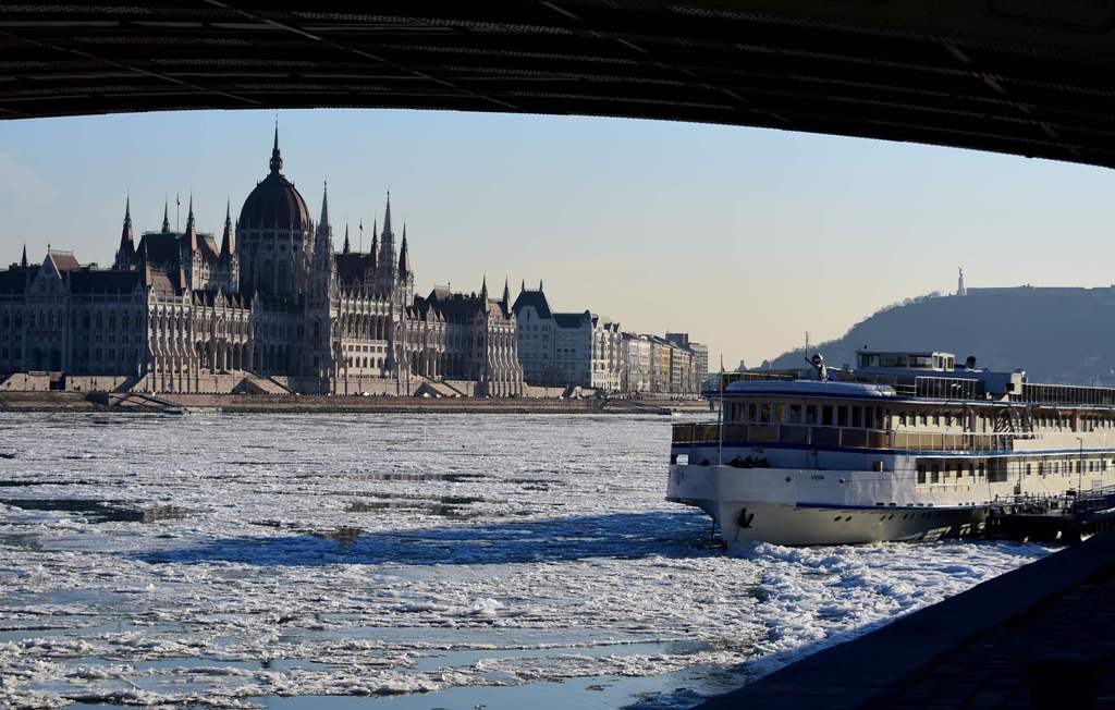 Ice floats in the water of the River Danube in front of the parliament buiding of Budapest downtown on January 8, 2017, when the extreme winter temperature overtakes a new record in the capital with minus 18,6 degrees centigrade. / AFP / ATTILA KISBENEDEK