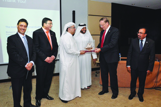 A IIA Qatar Chapter official presenting a memento to IIA Global President Richard F Chambers, in Doha. 