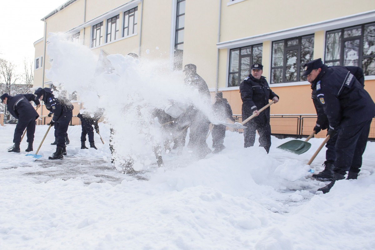Romanian gendarmes shovel snow in the courtyard of a school in Bucharest, Romania January 10, 2017. Inquam Photos/Octav Ganea/via REUTERS