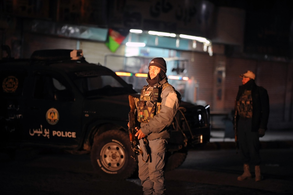 This picture taken on January 10, 2017 shows Afghan policemen standing guard at the site of an explosion near the governor's compound in Kandahar. AFP / JAWED TANVEER