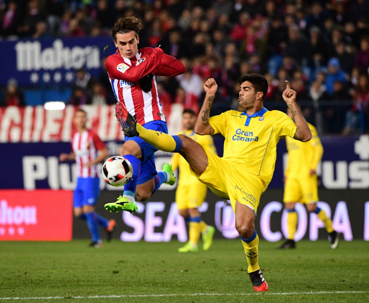 Atletico Madrid's French forward Antoine Griezmann (L) vies with Las Palmas' defender Aythami Artiles during the Spanish Copa del Rey (King's Cup) round of 16 second leg football match Club Atletico de Madrid vs UD Las Palmas at the Vicente Calderon stadi