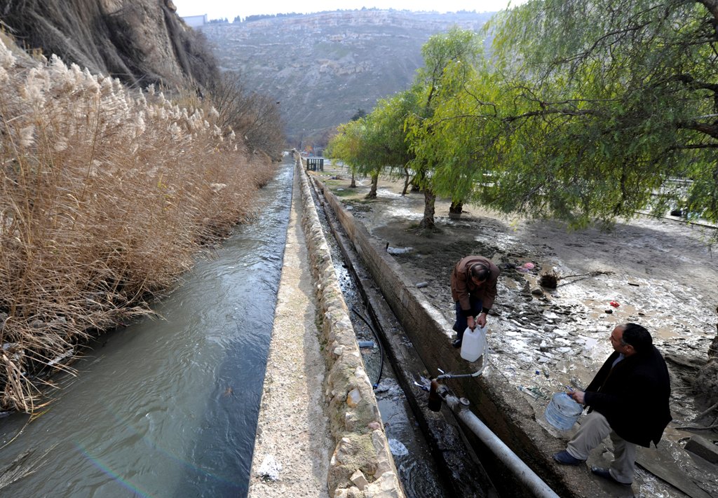 Men fill containers with water in the government controlled al-Rabwah area, a suburb of Damascus, Syria January 10, 2017. REUTERS/Omar Sanadiki