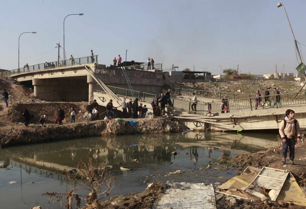 Displaced people who fled Islamic State militants, cross the bridge in Al-Muthanna neighborhood of Mosul, Iraq, January 9, 2017. REUTERS/Alaa Al-Marjani 

