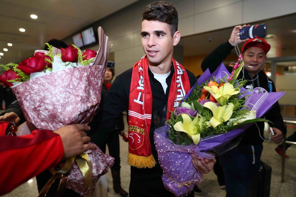(FILES) This file photo taken on January 2, 2017 shows Brazilian football player Oscar (C) receiving flowers as he arrives at Shanghai airport. Brazilian midfielder Oscar landed in Shanghai on January 2, 2017 where the 25-year-old was set to smash the Asi