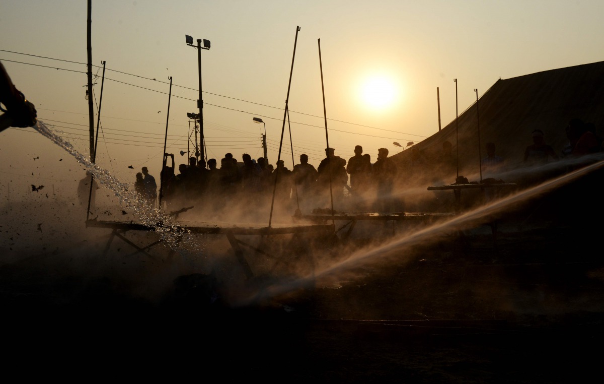 IN AN ANOTHER INCIDENT, Indian fire fighters douse a fire among the temporary tents used by the state police officials as bystanders watch on Gangasagar Island, around 150 kms south of Kolkata on January 14, 2017. More than 700,000 Hindu pilgrims and sadh
