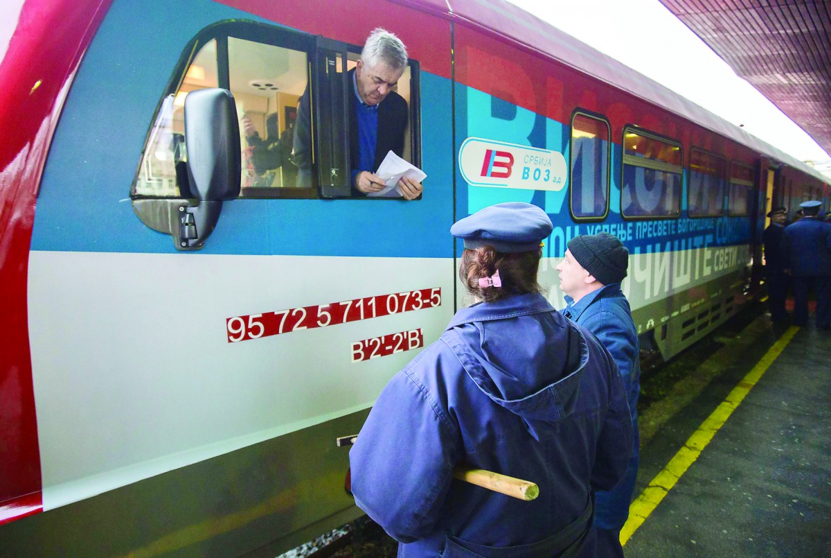 A train conductor speaks with local station workers at the main railway station in Belgrade on January 14, 2017. A train from Russia, decorated with the Serbian flag and artwork featuring Serbian churches, monasteries and medieval towns, plans to begin tr