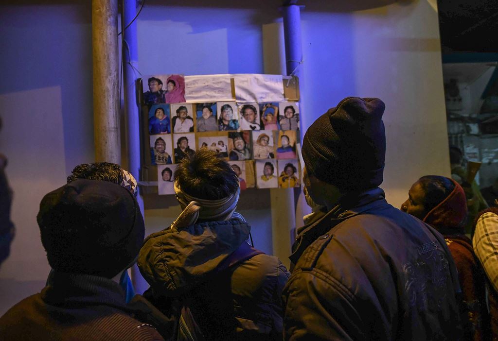 Relatives look at the images of people who drowned in a boat accident on the river Ganges near Patna in eastern India, on January 15, 2017. AFP