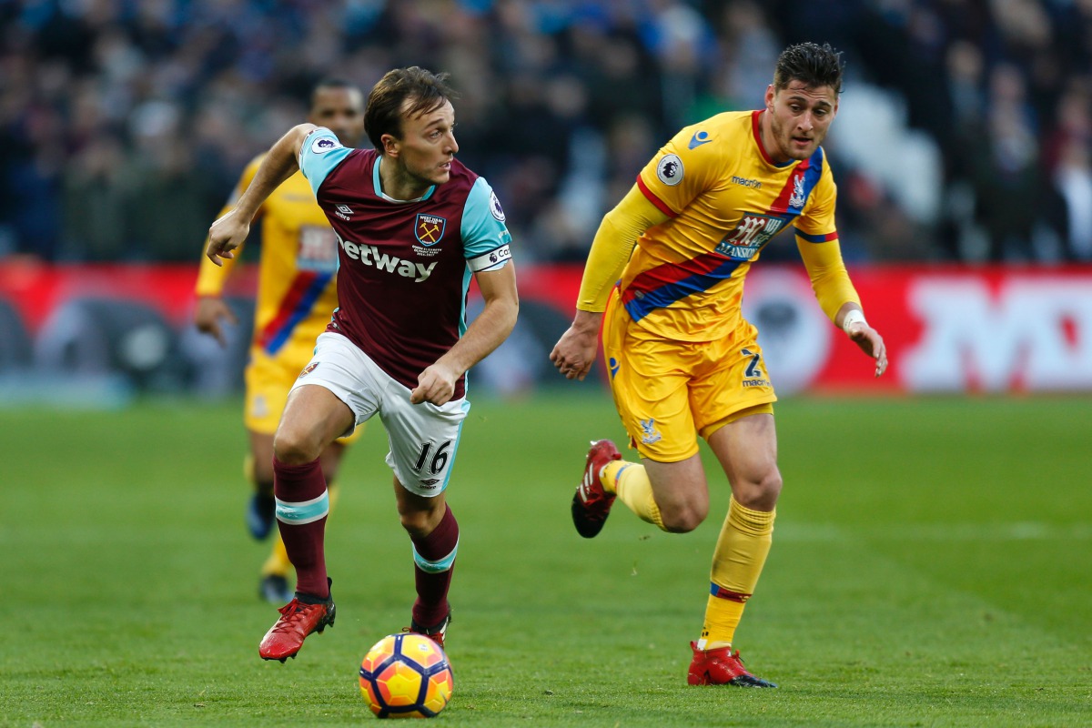 West Ham United's English midfielder Mark Noble runs away from Crystal Palace's English defender Joel Ward (R) during the English Premier League football match between West Ham United and Crystal Palace at The London Stadium, in east London on January 14,