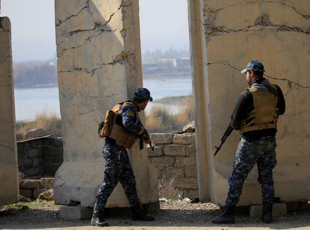 Iraqi Federal police take cover near the Tigris river during a battle with Islamic State militants in the district of Yarimja in southern Mosul, Iraq, January 14, 2017. REUTERS/Alaa Al-Marjani
