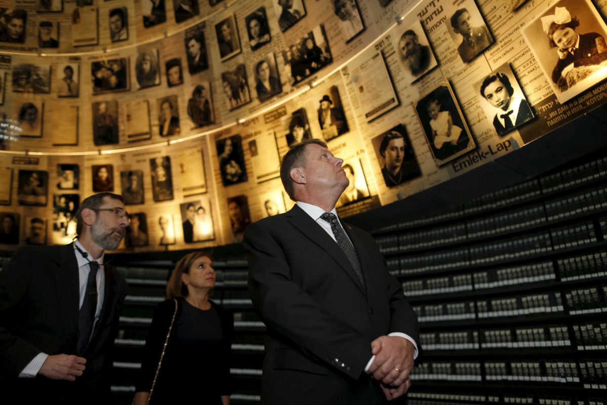 FILE PHOTO: Romanian President Klaus Iohannis looks at pictures of Jews killed in the Holocaust during a visit to the Hall of Names at Yad Vashems Holocaust History Museum in Jerusalem, March 8, 2016 (REUTERS / Ammar Awad) 