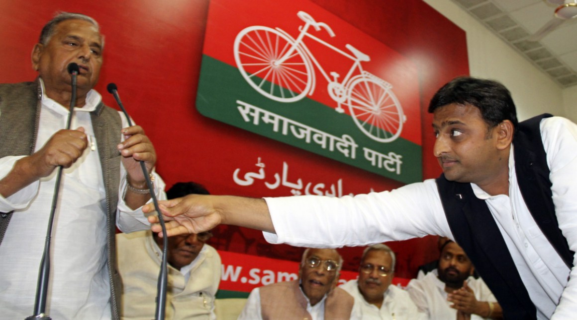 Akhilesh Yadav of Uttar Pradesh adjusts microphone for his father Mulayam Singh Yadav during a Samajwadi Party meeting in Lucknow, March 10, 2012 (Reuters file) 