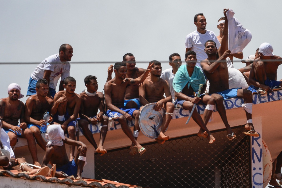 Inmates stand on the prison roof during a rebellion in Alcacuz Penitentiary Center near Natal, Rio Grande do Norte state, northeastern Brazil on January 16, 2017. The latest in a string of brutal prison massacres involving suspected gang members in Brazil