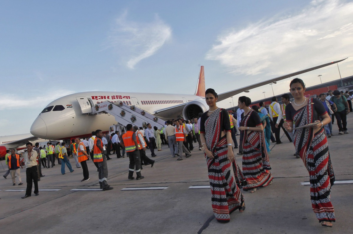 Air hostesses walk next to the parked Air India's Boeing 787-800 Dreamliner upon its arrival at the airport in New Delhi September 8, 2012. REUTERS/Mansi Thapliyal