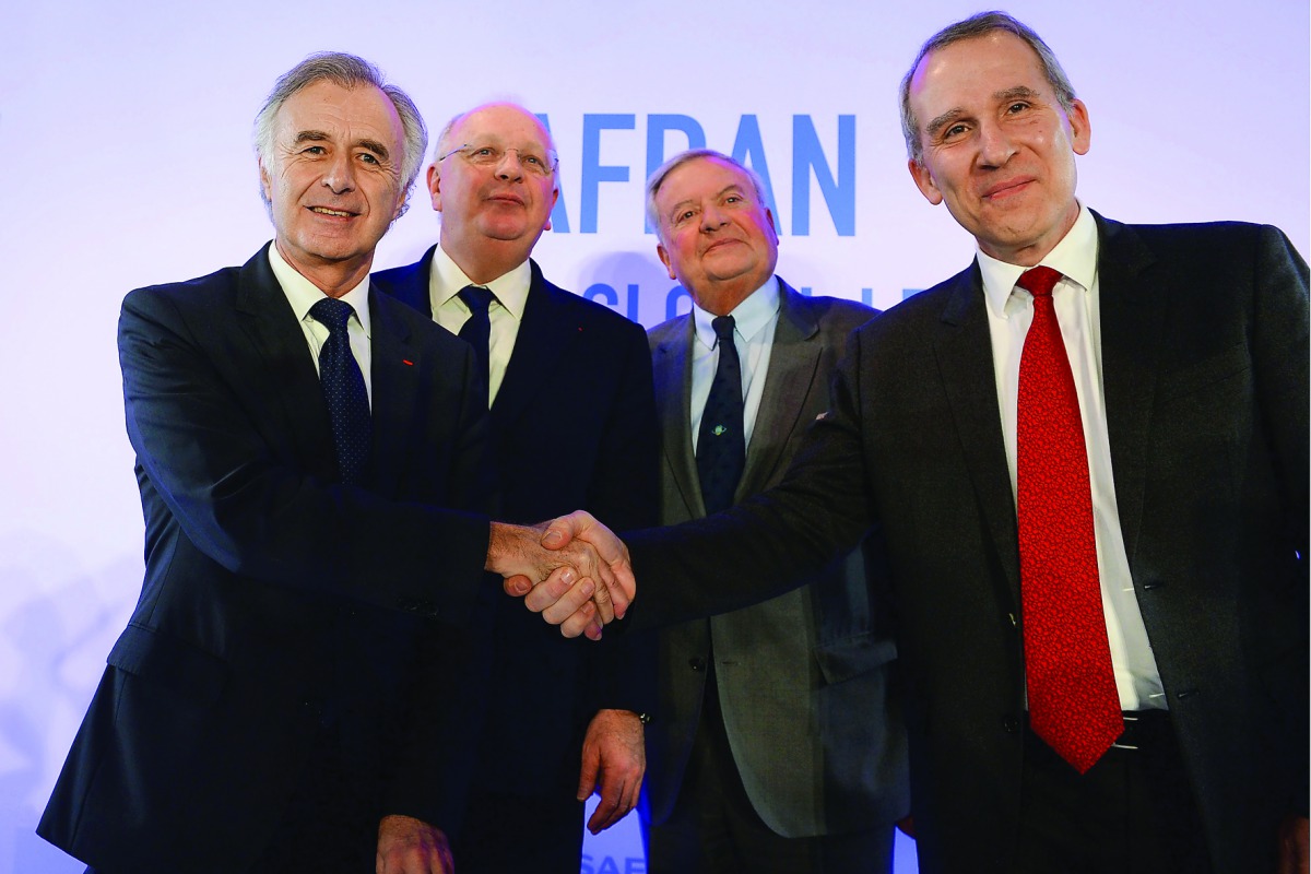 Safran CEO Philippe Petitcolin (left) Shakes hands with Zodiac Aerospace CEO Olivier Zarrouati (right) next to Safran Chairman of board Ross McInnes (second left) and Zodiac Aerospace supervisory Board Chairman Didier Domange at the end of a press confere