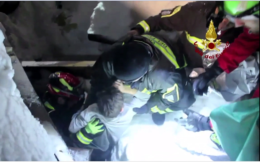 A handout picture released on January 20, 2017 by the Vigili del Fuoco shows a child (C) being rescued from the Hotel Rigopiano, near the village of Farindola, on the eastern lower slopes of the Gran Sasso mountain, engulfed by a powerful avalanche a day 