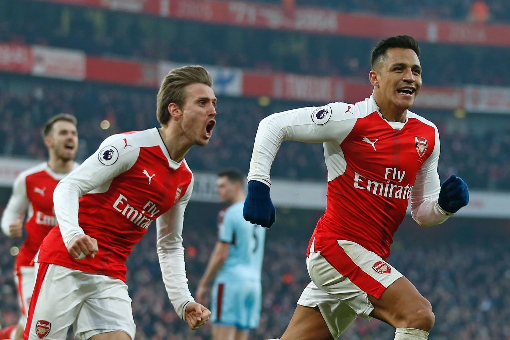 Arsenal's Chilean striker Alexis Sanchez (R) celebrates with Arsenal's Spanish defender Nacho Monreal (2nd L) after scoring their late winner from the penalty spot during the English Premier League football match between Arsenal and Burnley at the Emirate