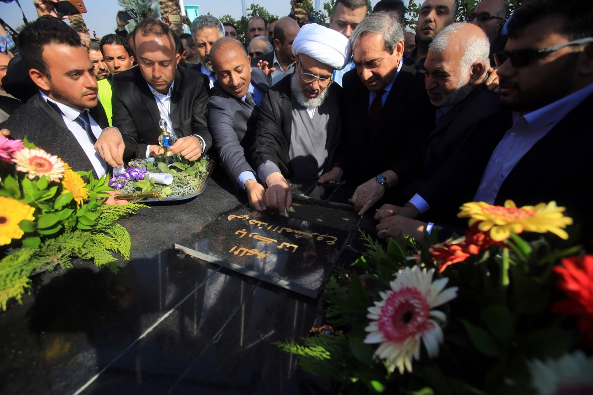 Sheikh Abdul Mahdi al-Karbalai (C), the representative of Iraq's Shiite spiritual leader Grand Ayatollah Ali Sistani who is in charge of the Imam Hussein Holy Shrine, and Sami al-Araji (C-R), head of Iraq's National Investment Commission, lay the cornerst