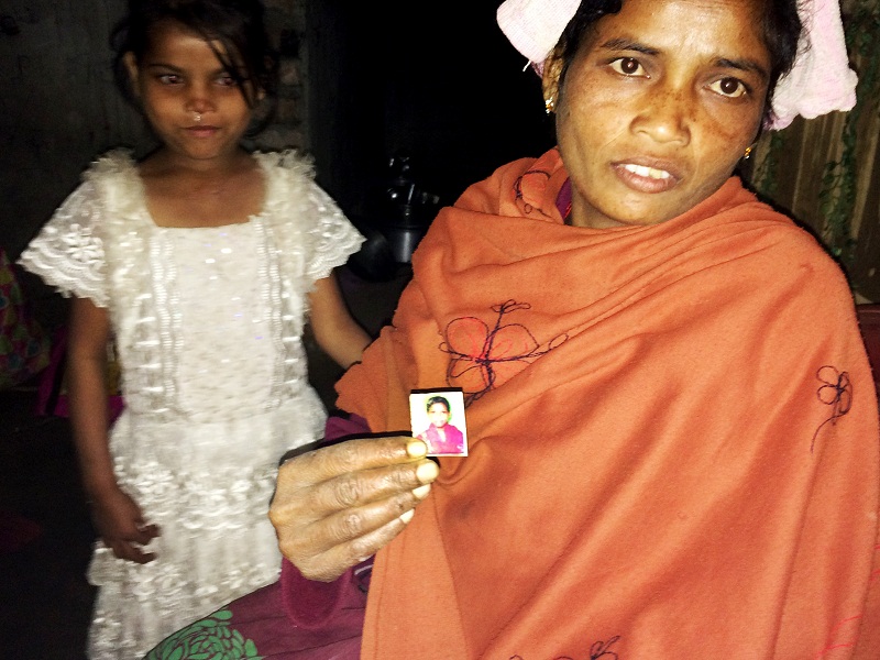 Rukmani Naik poses with a picture of her 14-year-old daughter who left their home in the Diana Tea Estate in West Bengal, India, to work in another city. January 12, 2017 (Reuters)