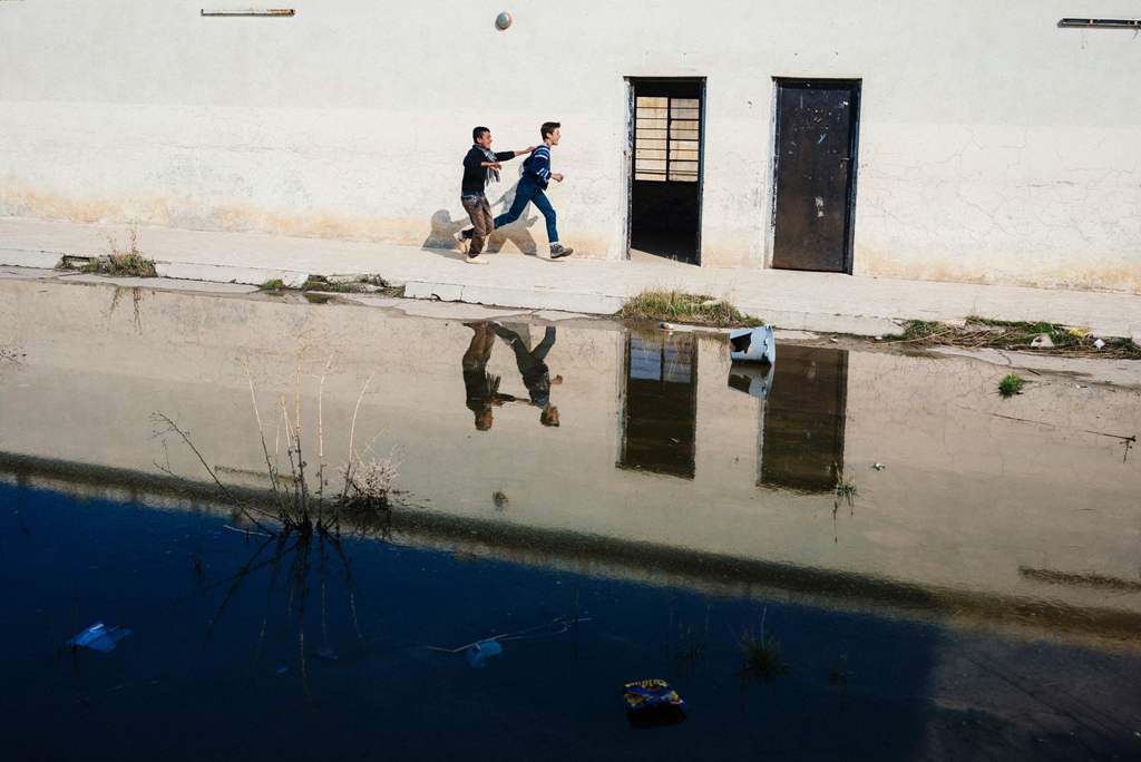 Iraqi students run in a school yard at a school in Mosul's eastern Gogjali neighbourhood on January 23, 2017, as scores of schools resumed their activities in the areas government forces recently recaptured from the Islamic State (IS) group during the gov