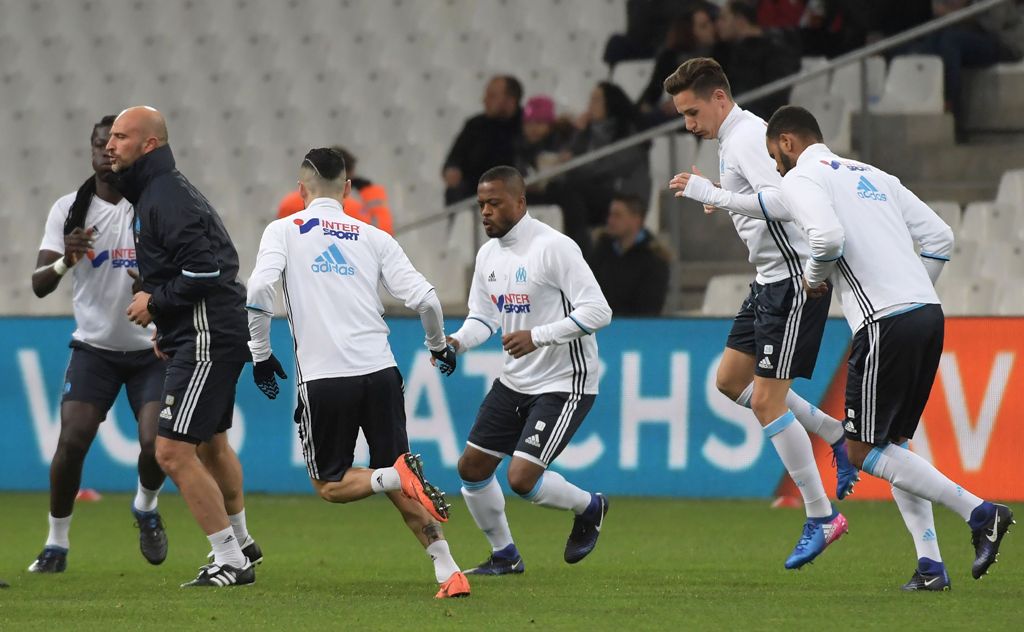 Marseille's new French defender Patrice Evra (C) warms up with teammates before the French L1 football match between Marseille (OM) vs Montpellier (MHSC) at the Velodrome Stadium in Marseille, southern France, on January 27, 2017. / AFP / ANNE-CHRISTINE P