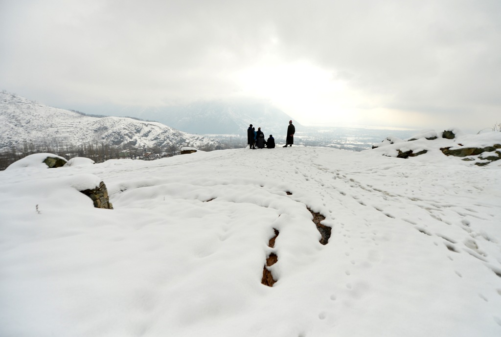 Kashmiri villagers look from the top of a hill on the outskirts of Srinagar after a heavy snowfall, in Srinagar on January 27, 2017. / AFP / Tauseef MUSTAFA