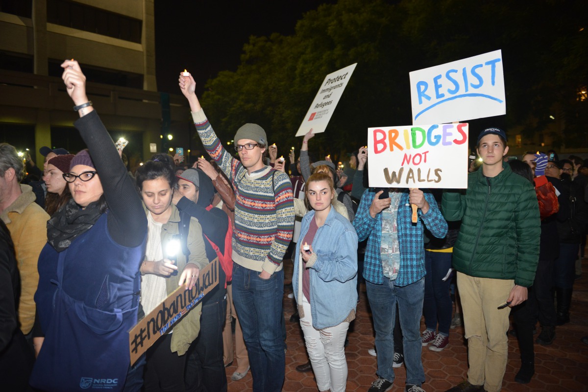 People hold banners and candles during the candlelight vigil held to protest against President Donald Trump's decision for a wall between Mexico and US borders and over visa ban for some Muslim countries in Los Angeles, CA, USA on January 26, 2017. (Aydin