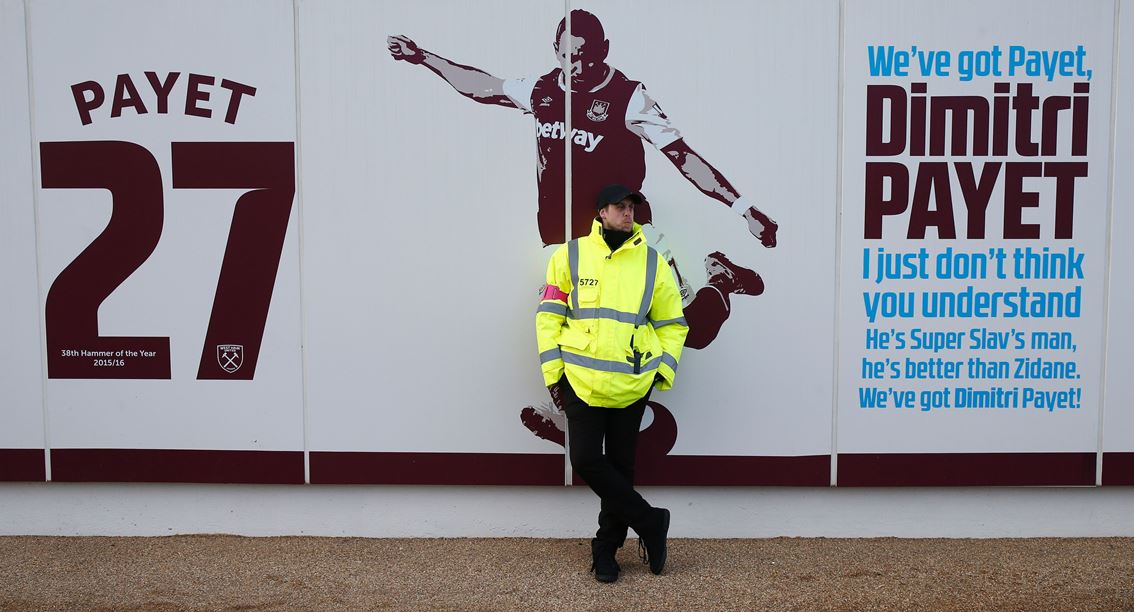 (FILES) This file photo taken on January 14, 2017 shows a security guard standing beside the club mural praising West Ham United's French midfielder Dimitri Payet ahead of the English Premier League football match between West Ham United and Crystal Palac