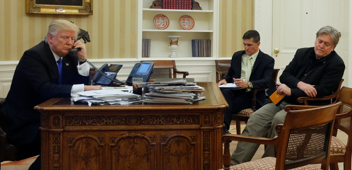 U.S. President Donald Trump (L), seated at his desk with National Security Advisor Michael Flynn (2nd R) and senior advisor Steve Bannon (R), speaks by phone with Australia's Prime Minister Malcolm Turnbull in the Oval Office at the White House in Washing