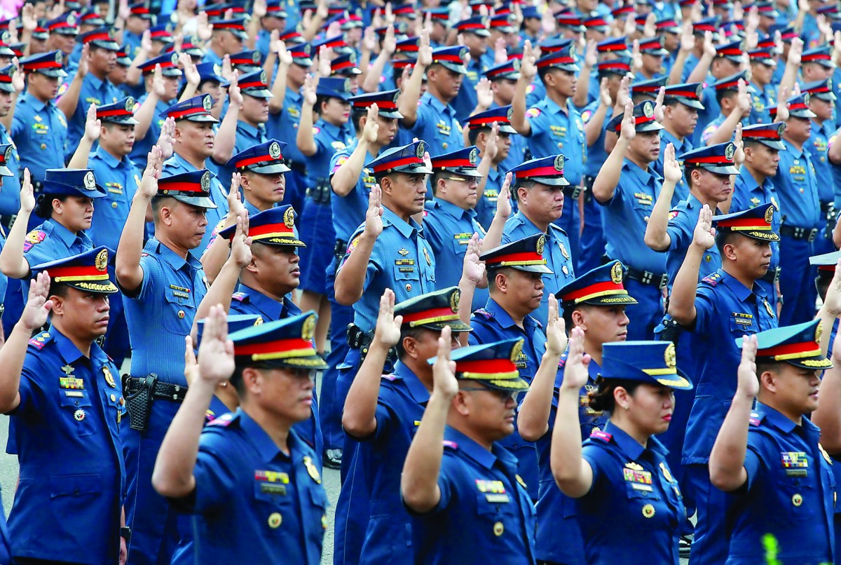 Police officers take oath at the Philippine National Police (PNP) headquarters in Quezon City, Metro Manila, yesterday.