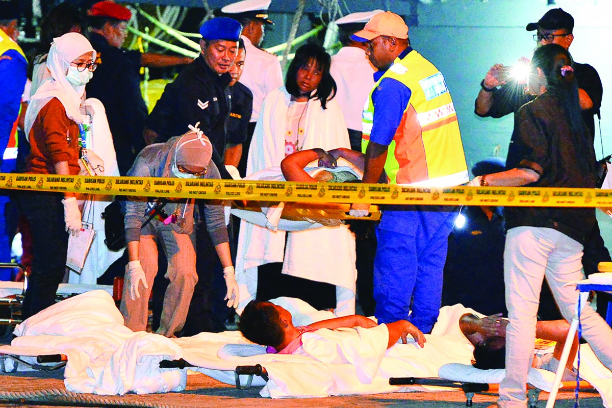 Rescue personnel and medics assist survivors at a jetty in Kota Kinabalu, sabah.