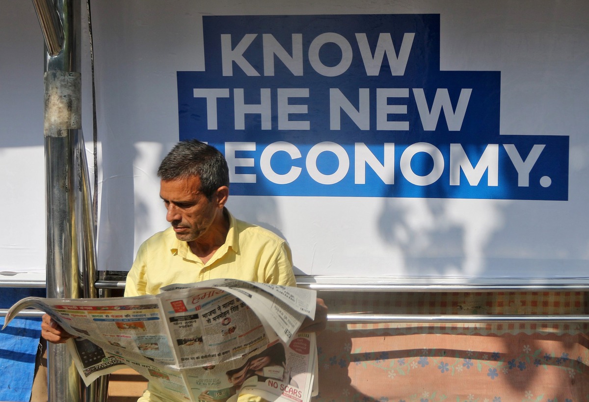 A man reads a newspaper as he waits for public transport at a bus stop in Mumbai, India, January 31, 2017. (REUTERS/Shailesh Andrade)
