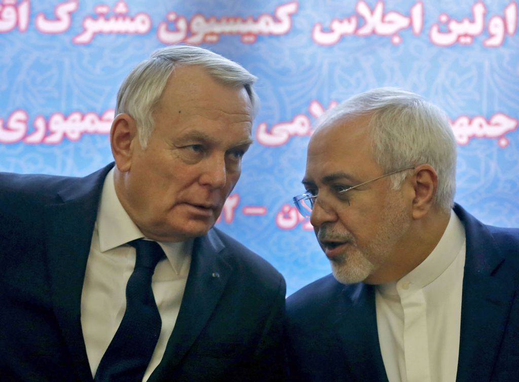 French Foreign Minister Jean-Marc Ayrault (L) and Iranian Foreign Minister Mohammad Javad Zarif smile after signing economic agreements in Tehran on January 31, 2017.  AFP / ATTA KENARE
