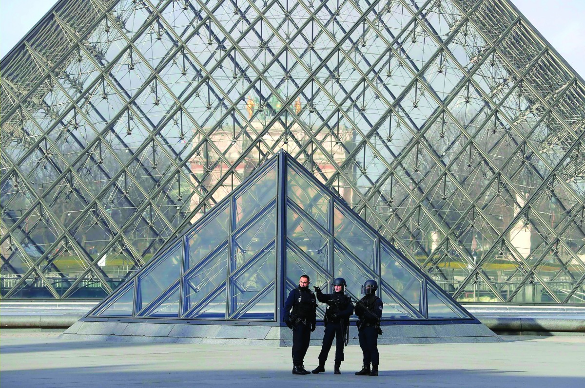 French police secure the site near the Louvre Pyramid in Paris, yesterday.