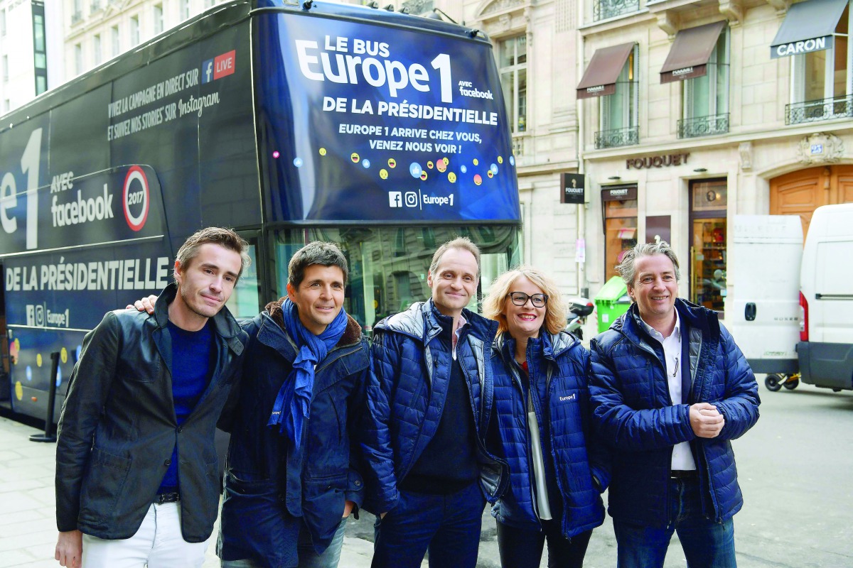 (LtoR) French journalists Nicolas Escoulan, Thomas Sotto, Fabien Namias, Isabelle Millet, and Nicolas Poincare pose for a picture during the launch of radio Europe 1's 'presidential bus' in Paris on February 3, 2017. AFP / Christophe Archambault