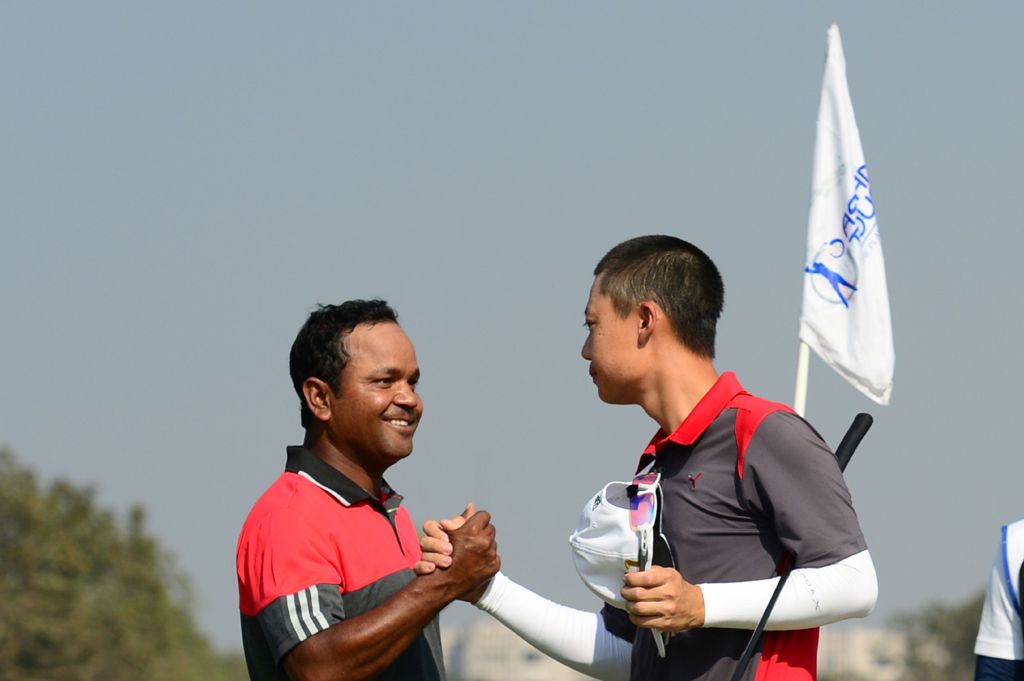 Jazz Janewattananond of Thailand (R) celebrates with Siddikur Rahman (L) of Bangladesh after winning the final round of the Bangladesh Open golf tournament at the Kurmitola Golf Club in Dhaka on February 4, 2017. / AFP / STR
