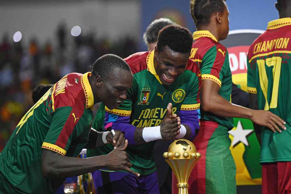 Cameroon's goalkeeper Fabrice Ondoa (C) and Cameroon's forward Vincent Aboubakar (L) react to the winner's trophy after Cameroon beat Egypt 2-1 in the 2017 Africa Cup of Nations final football match between Egypt and Cameroon at the Stade de l'Amitie Sino