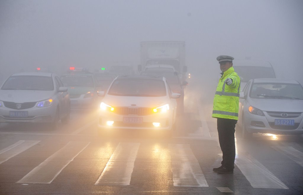 A traffic police works among heavy smog during a polluted day in Bozhou, Anhui province, China, February 5, 2017. REUTERS/Stringer