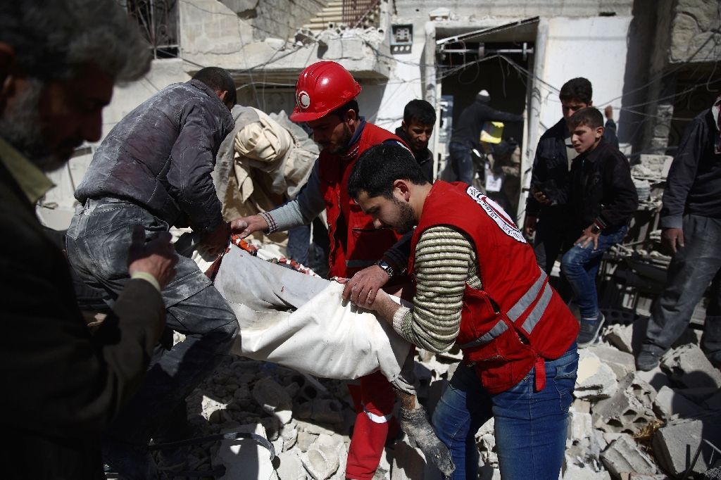 Members of the Syrian Arab Red Crescent and residents search through the rubble for bodies following an airstrike in the rebel-held city of Douma in Eastern Ghouta, on February 26, 2016 (AFP Photo/Abd Doumany).